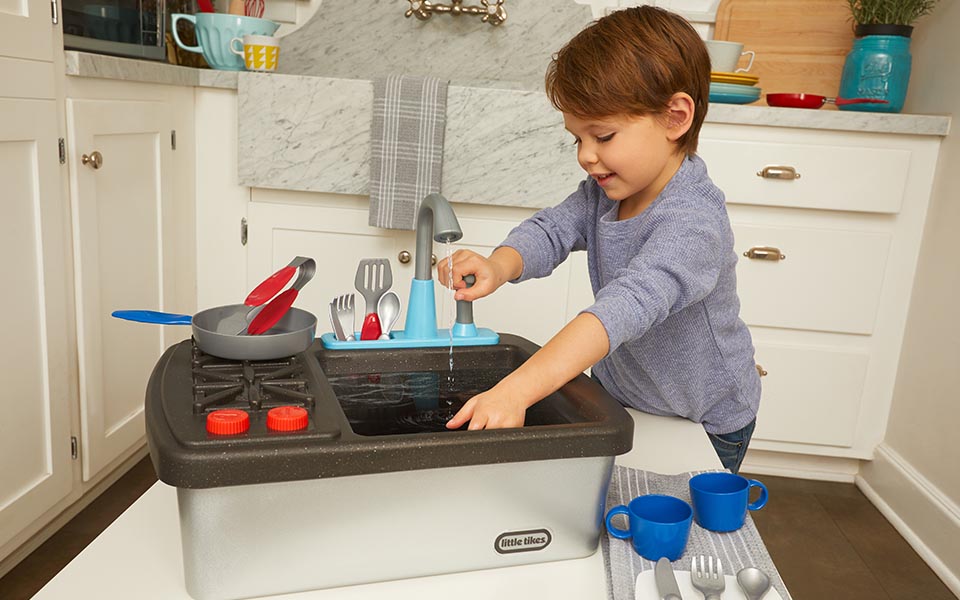 Child playing with toy dish washer