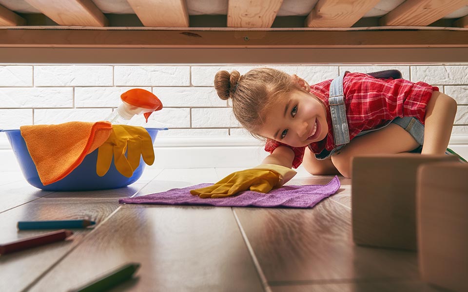 Girl cleaning under the bed
